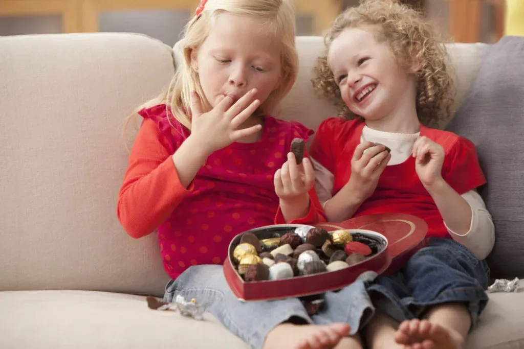 Two little girls enjoy their special Valentine’s Day candy.